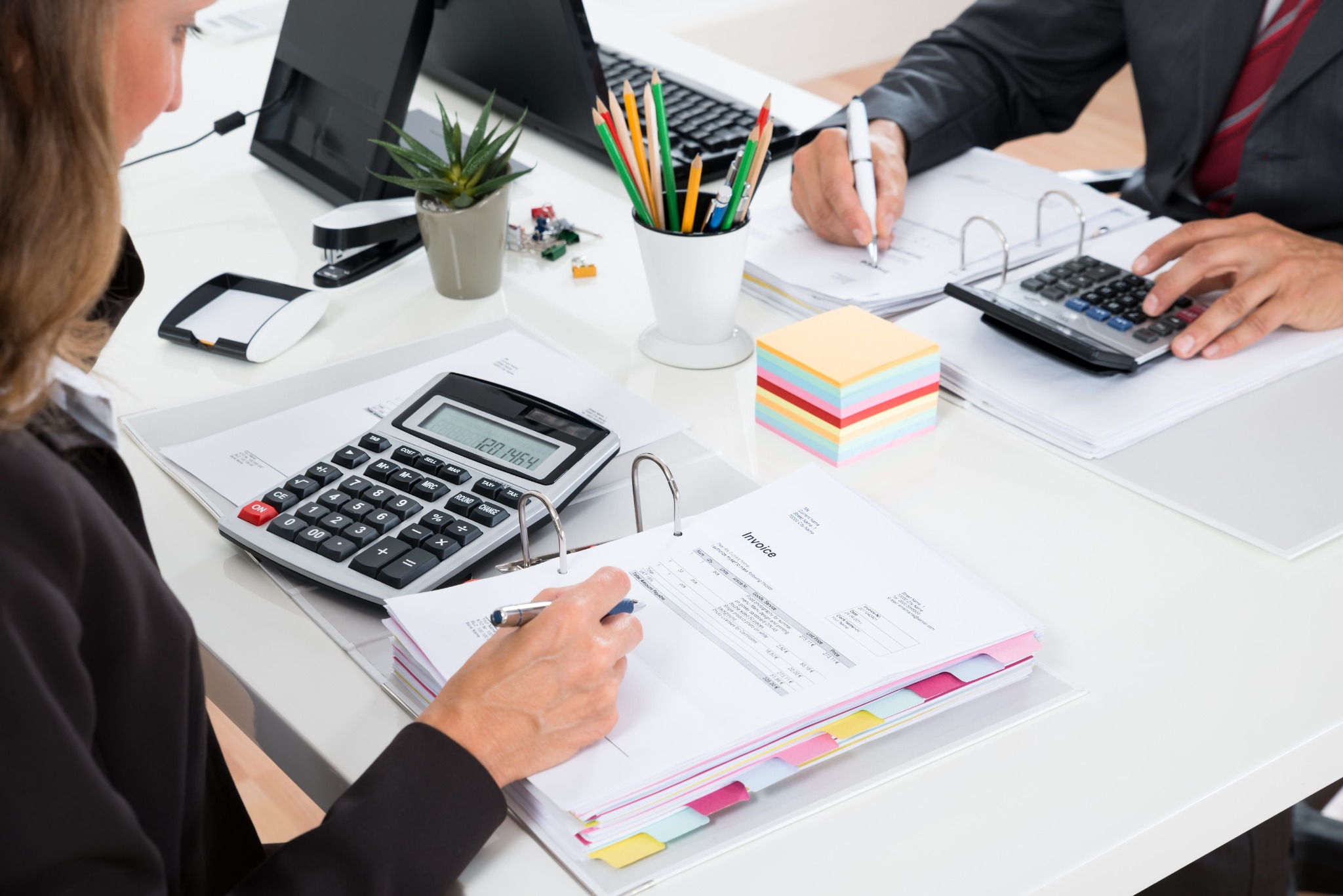Accountants reviewing company formation documents with a calculator