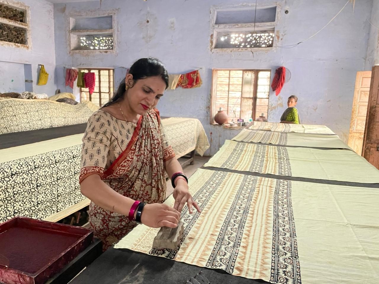A woman hand block-printing fabric at a workshop in Bagru, Jaipur