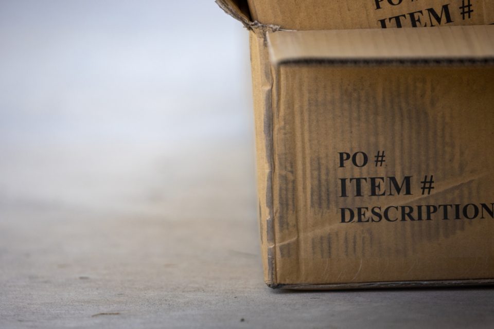 A corrugated shipping box with a purchase order label